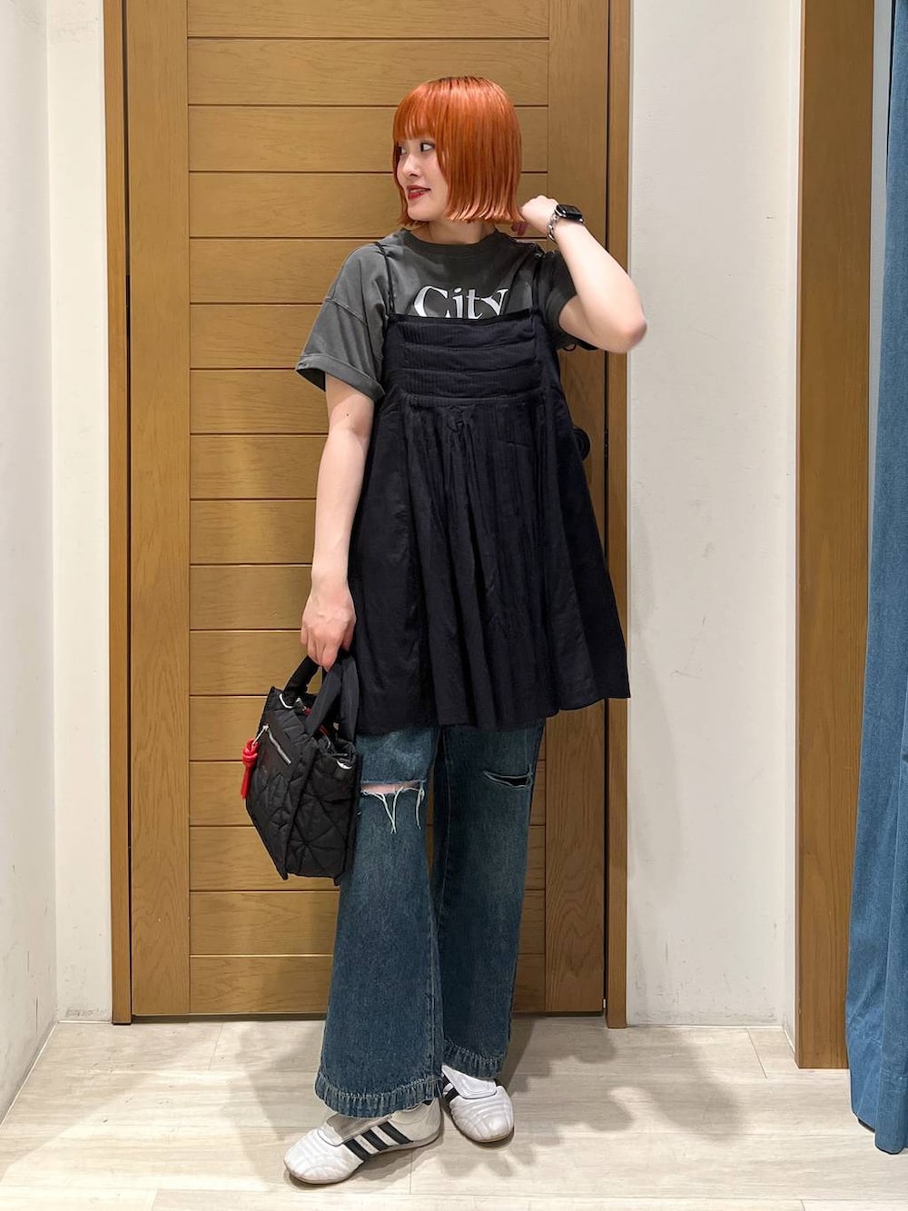 グレー系のTシャツ/カットソー、ブルー系のデニムパンツ、ブラック系のショルダーバッグを着用したレディースの夏コーディネートの3枚目の写真