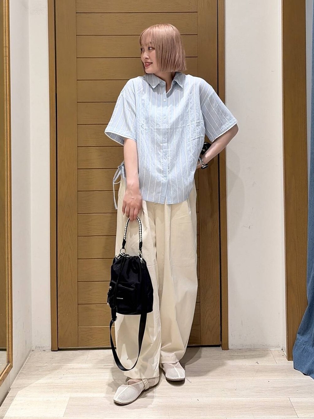 ホワイト系のその他パンツ、ホワイト系のパンプス、ベージュ系のショルダーバッグを着用したレディースの夏コーディネートの2枚目の写真