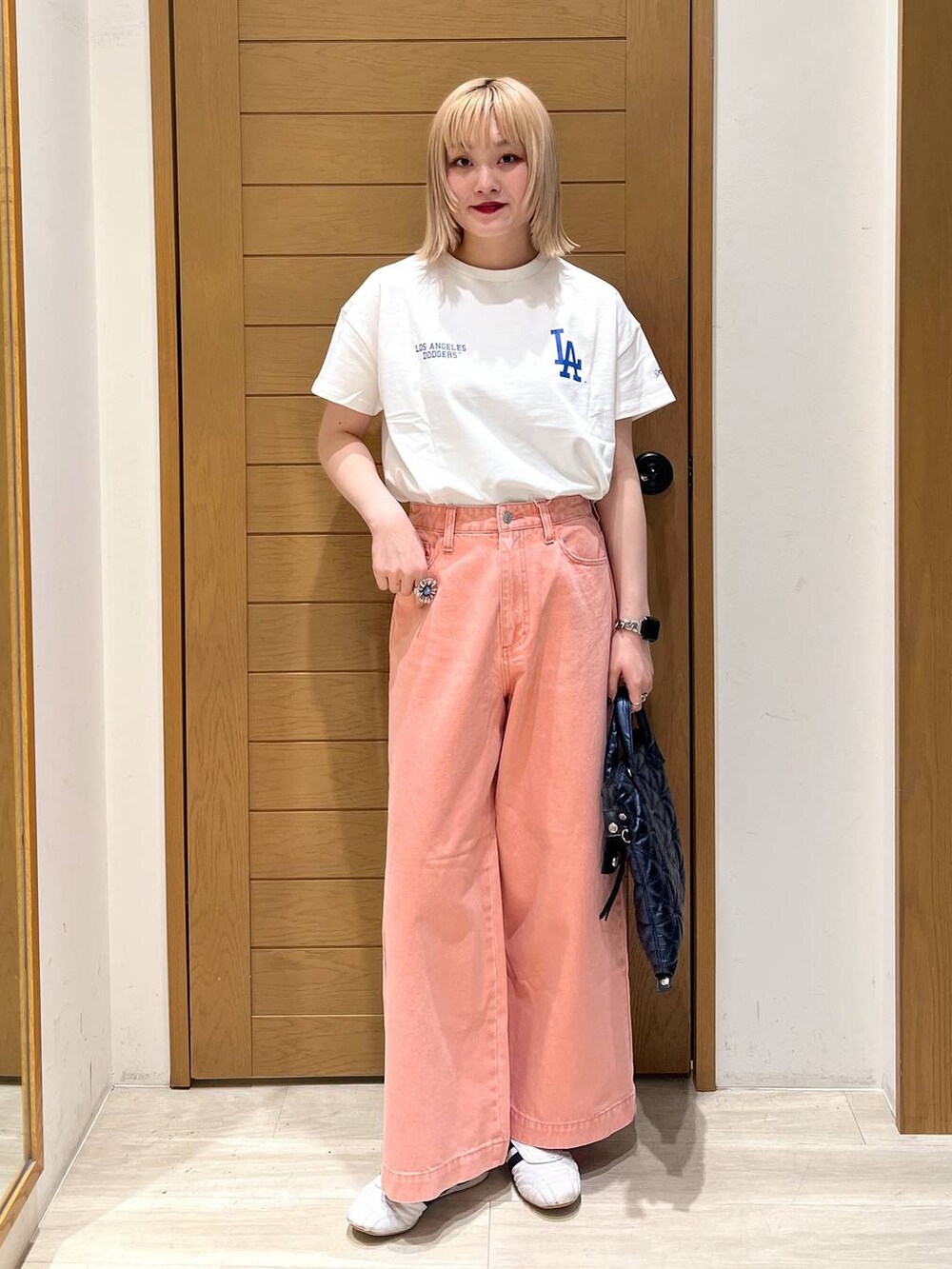 ピンク系のデニムパンツ、ブルー系のハンドバッグ、ホワイト系のTシャツ/カットソーを着用したレディースの春コーディネートの7枚目の写真