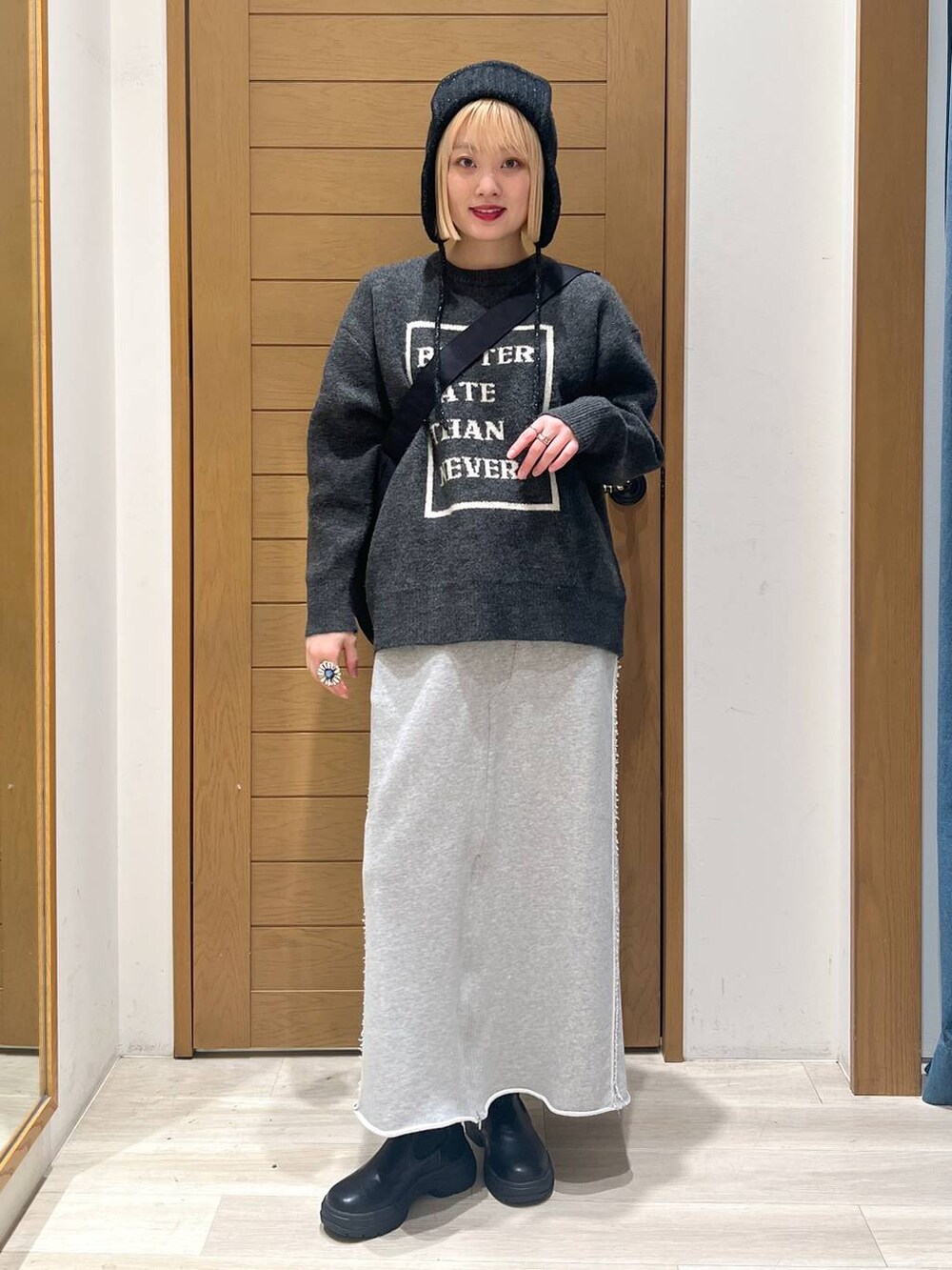 ブラック系のブーツ、グレー系のニット/セーター、ブラック系のショルダーバッグを着用したレディースの冬コーディネートの5枚目の写真