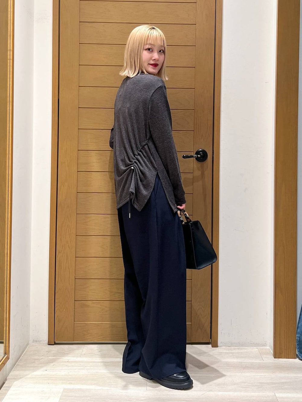 ブラック系のハンドバッグ、ブルー系のその他パンツ、その他のローファーを着用したレディースの冬コーディネートの2枚目の写真