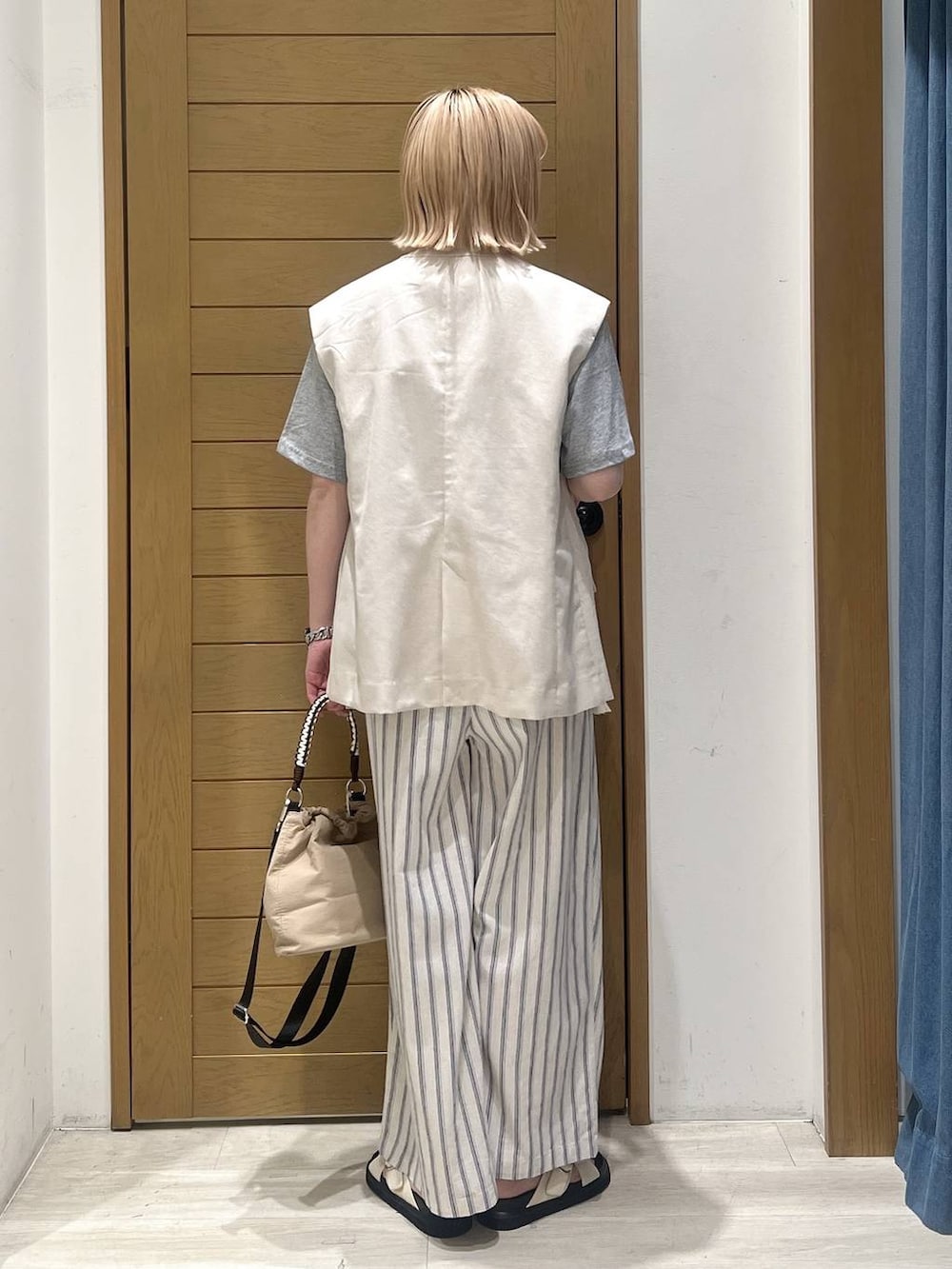 ホワイト系のその他パンツ、ベージュ系のショルダーバッグ、ホワイト系のサンダルを着用したレディースの春コーディネートの5枚目の写真