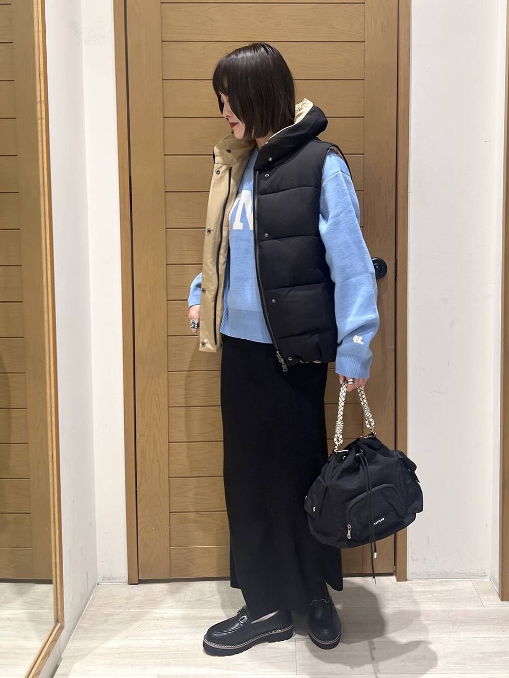 ブルー系のニット/セーター、ブラック系のローファー、ブラック系のハンドバッグを着用したレディースの秋コーディネートの3枚目の写真
