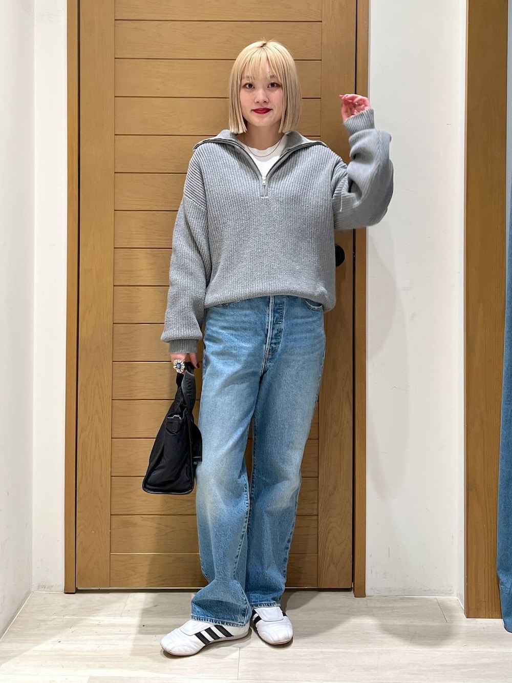 ブルー系のデニムパンツ、ブラック系のトートバッグ、グレー系のニット/セーターを着用したレディースの冬コーディネートの5枚目の写真