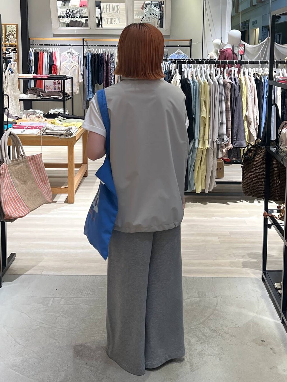 グレー系のスウェットパンツ、ブルー系のトートバッグを着用したレディースの夏コーディネートの4枚目の写真