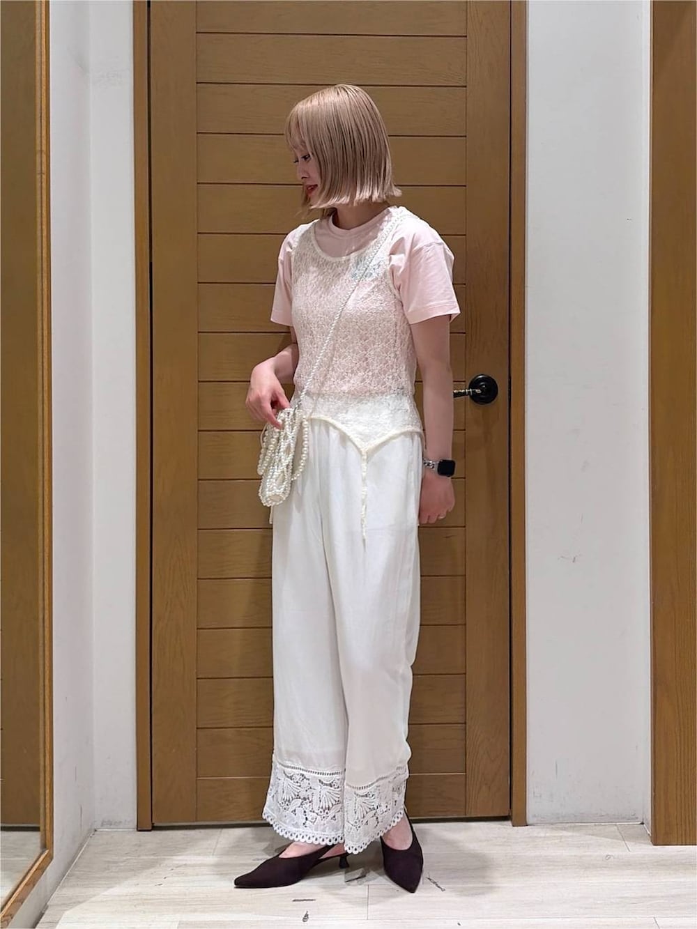 その他のショルダーバッグ、ブラウン系のパンプス、ホワイト系のタンクトップを着用したレディースの夏コーディネートの3枚目の写真