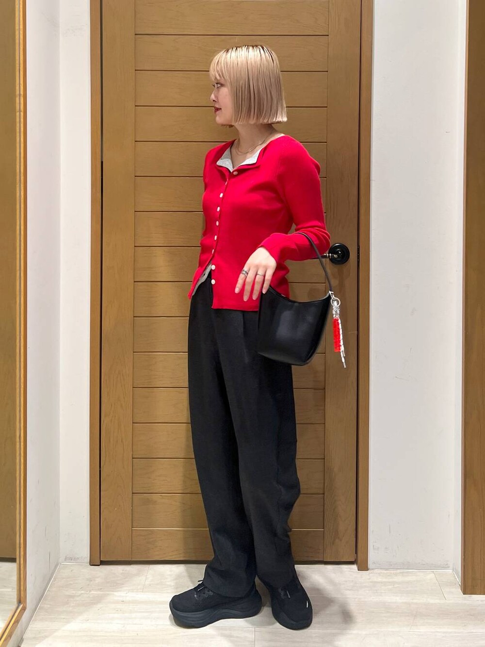 ブラック系のハンドバッグ、グレー系のカーディガン/ボレロ、グレー系のその他パンツを着用したレディースの秋コーディネートの2枚目の写真