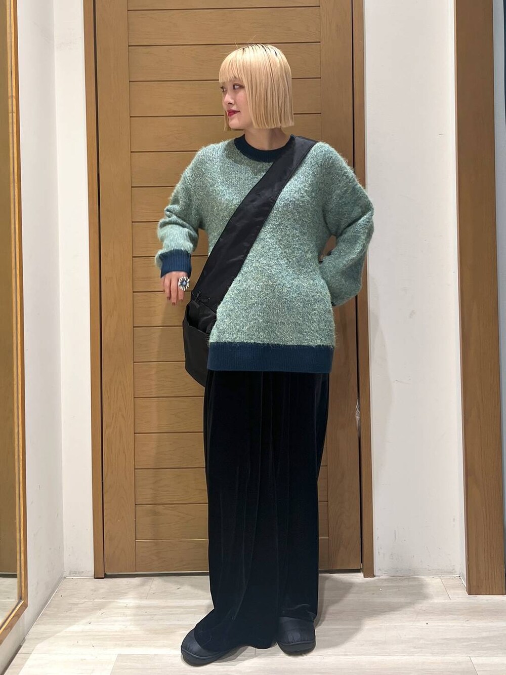 グリーン系のニット/セーター、ブラック系のショルダーバッグ、ブラック系のその他パンツを着用したレディースの冬コーディネートの6枚目の写真