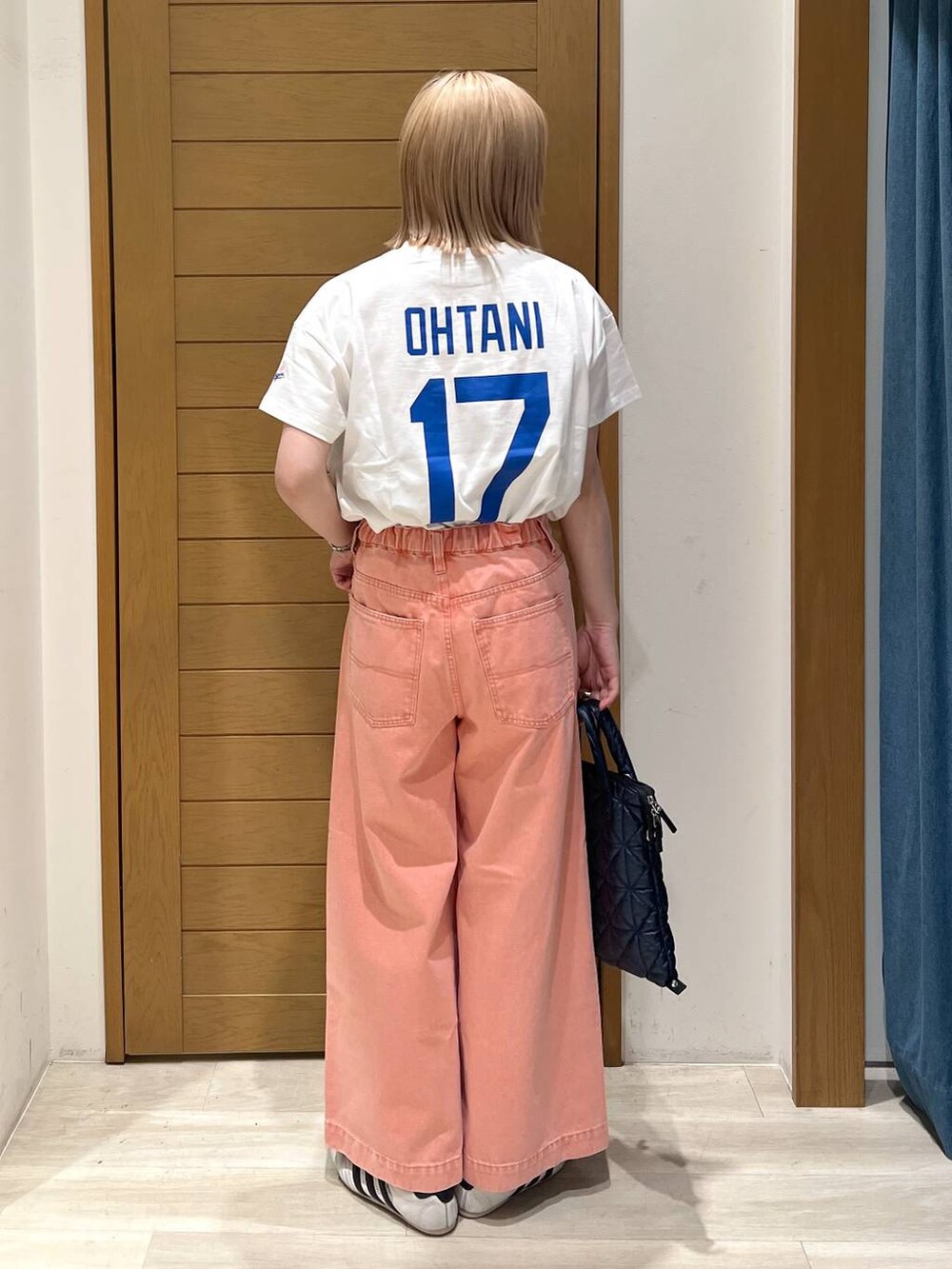 ピンク系のデニムパンツ、ブルー系のハンドバッグ、ホワイト系のTシャツ/カットソーを着用したレディースの春コーディネートの3枚目の写真