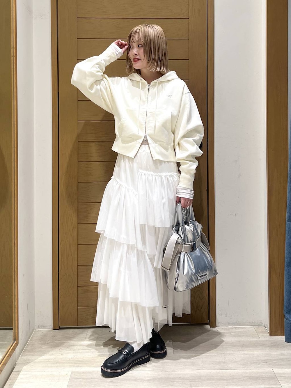 シルバー系のトートバッグ、ブラック系のローファー、ホワイト系のTシャツ/カットソーを着用したレディースの春コーディネートの3枚目の写真