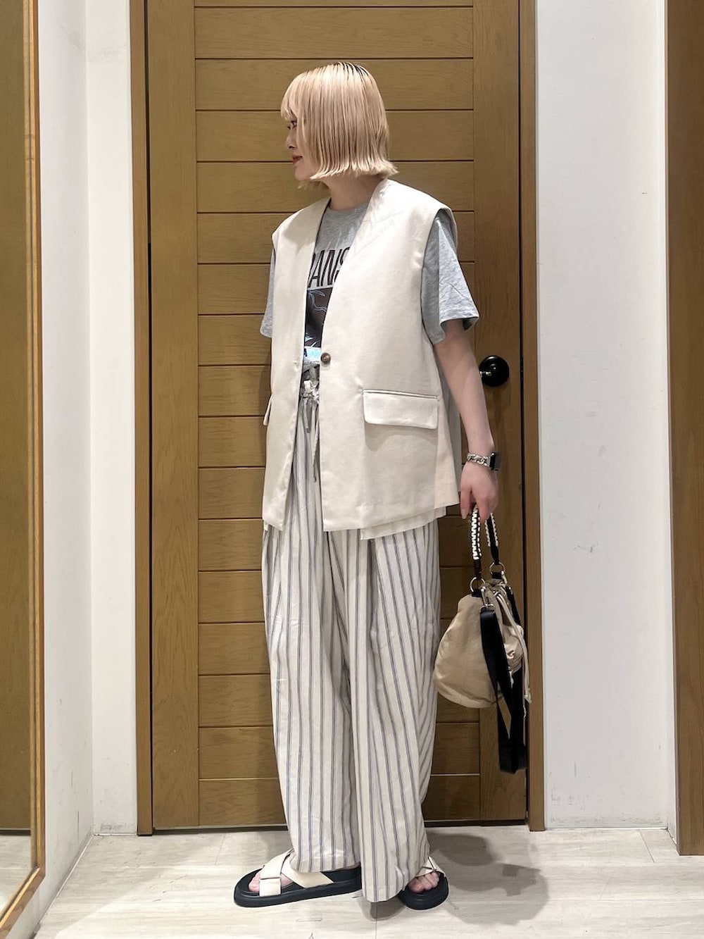 ホワイト系のその他パンツ、ベージュ系のショルダーバッグ、ホワイト系のサンダルを着用したレディースの春コーディネートの3枚目の写真