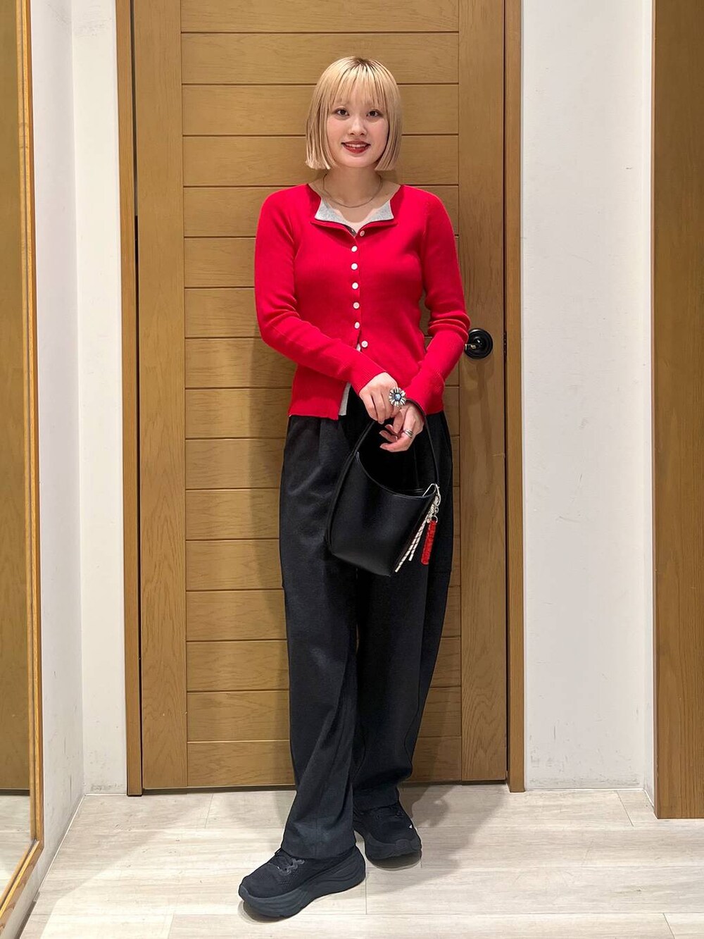 ブラック系のハンドバッグ、グレー系のカーディガン/ボレロ、グレー系のその他パンツを着用したレディースの秋コーディネートの3枚目の写真