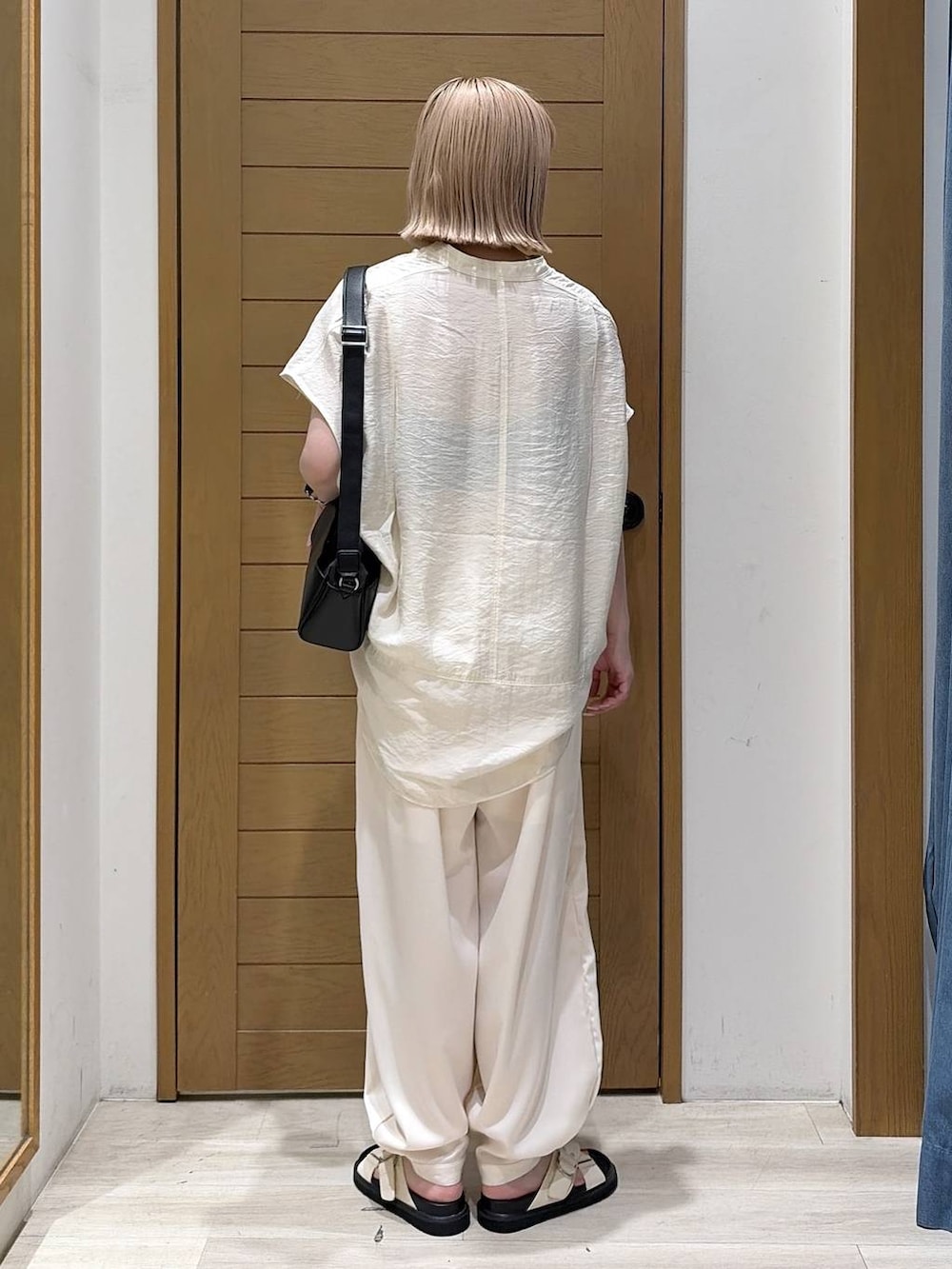 ベージュ系のその他パンツ、ホワイト系のシャツ/ブラウス、ホワイト系のサンダルを着用したレディースの夏コーディネートの3枚目の写真