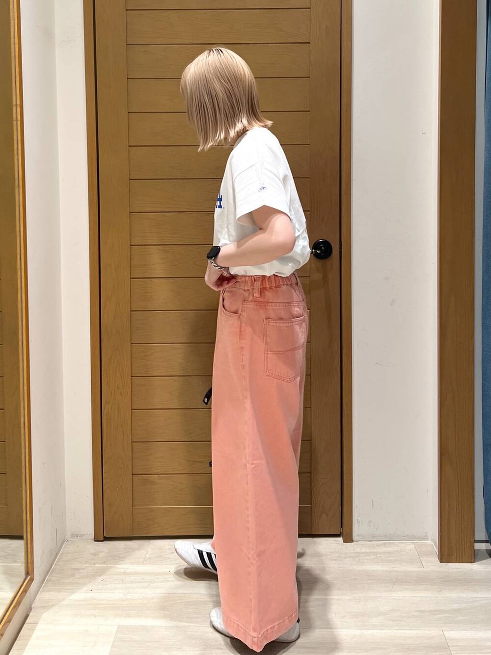 ピンク系のデニムパンツ、ブルー系のハンドバッグ、ホワイト系のTシャツ/カットソーを着用したレディースの春コーディネートの5枚目の写真