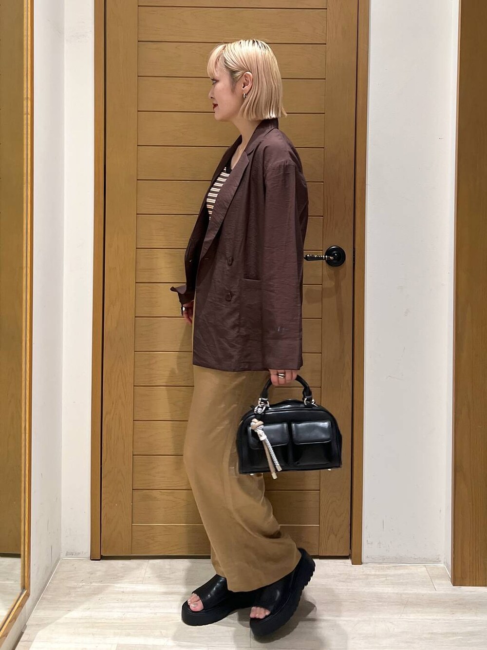 ブラック系のボストンバッグ、ブラウン系のその他パンツ、ブラウン系のテーラードジャケットを着用したレディースの夏コーディネートの3枚目の写真