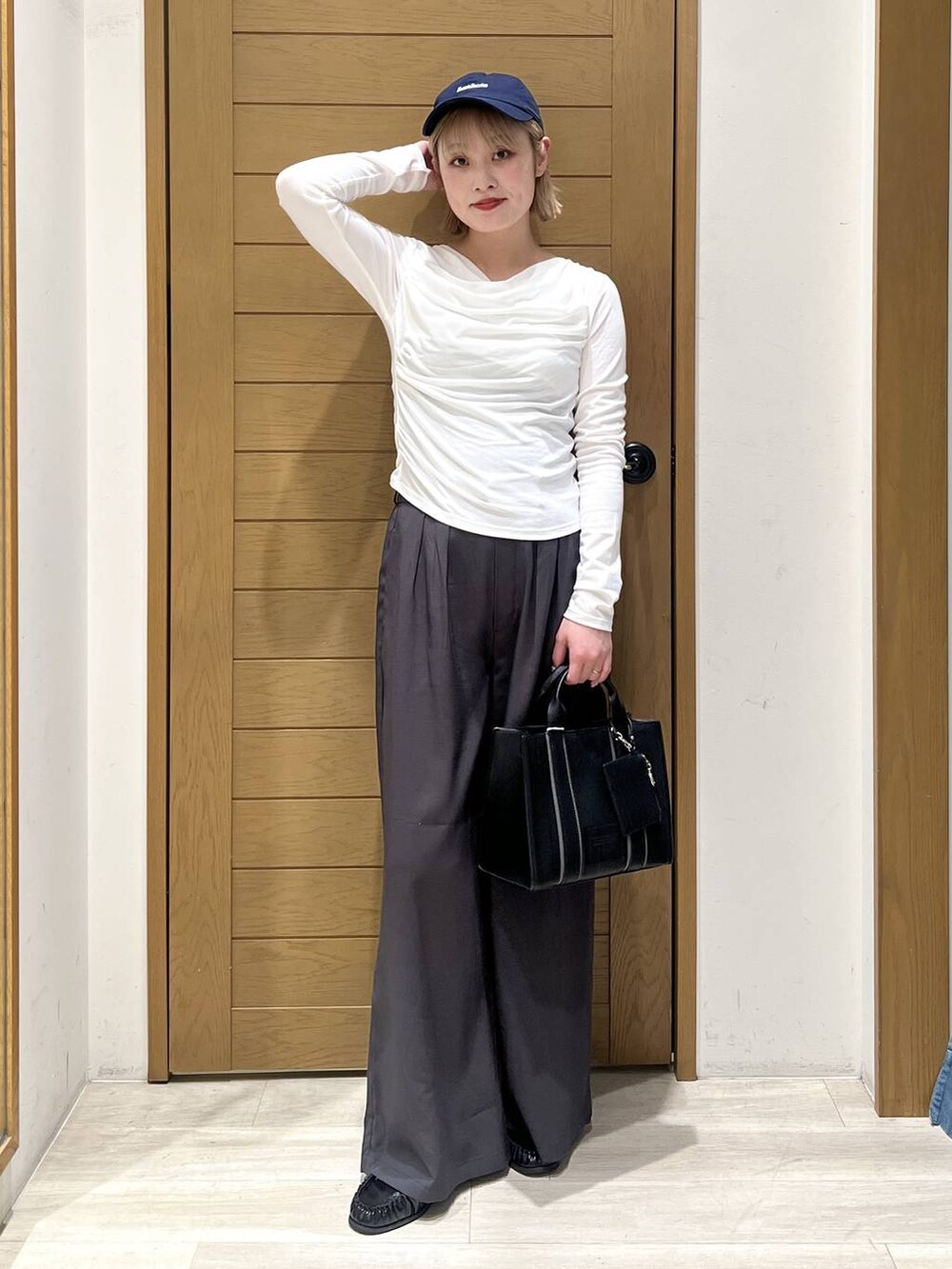 ブラック系のハンドバッグ、ブラック系のローファー、グレー系のその他パンツを着用したレディースの冬コーディネートの6枚目の写真