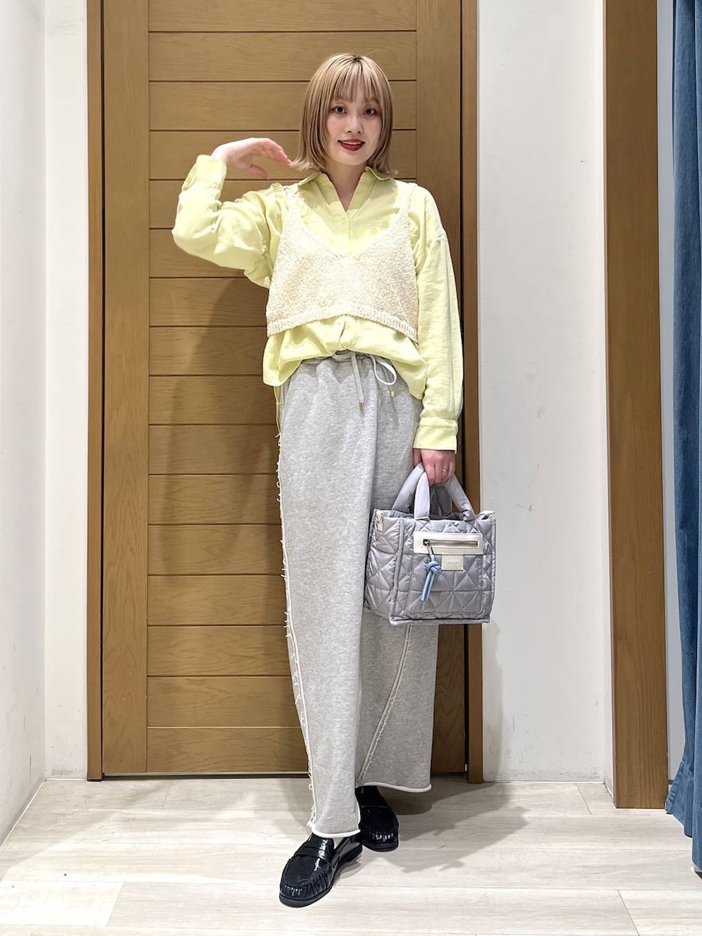 グレー系のショルダーバッグ、グレー系のスカート、ブラック系のローファーを着用したレディースの春コーディネートの2枚目の写真