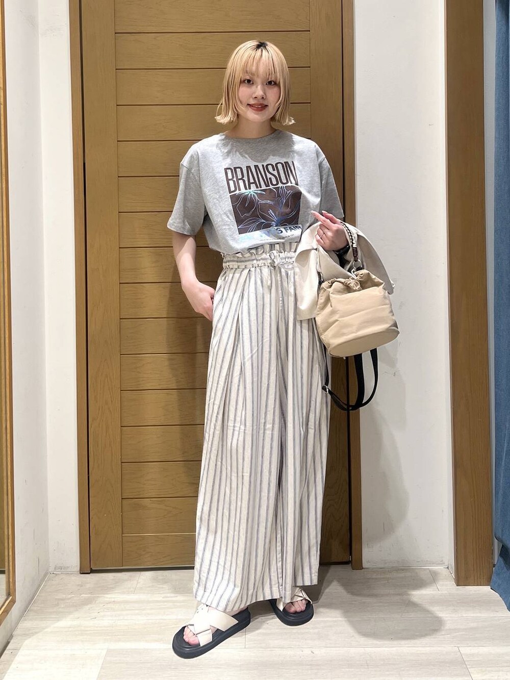 ホワイト系のその他パンツ、ベージュ系のショルダーバッグ、ホワイト系のサンダルを着用したレディースの春コーディネートの6枚目の写真