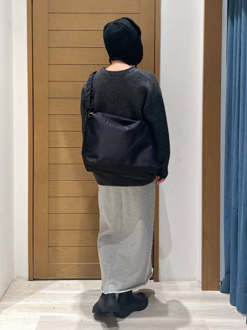 ブラック系のブーツ、グレー系のニット/セーター、ブラック系のショルダーバッグを着用したレディースの冬コーディネートの4枚目の写真