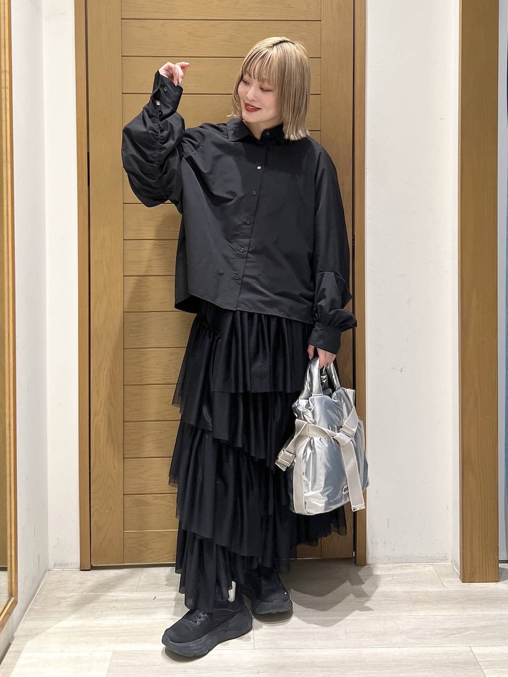 シルバー系のトートバッグ、ブラック系のシャツ/ブラウス、ブラック系のスカートを着用したレディースの春コーディネートの2枚目の写真