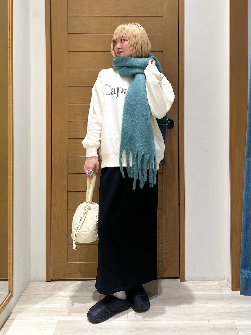 ベージュ系のショルダーバッグ、ホワイト系のスウェット、ブラック系のスカートを着用したレディースの冬コーディネートの6枚目の写真