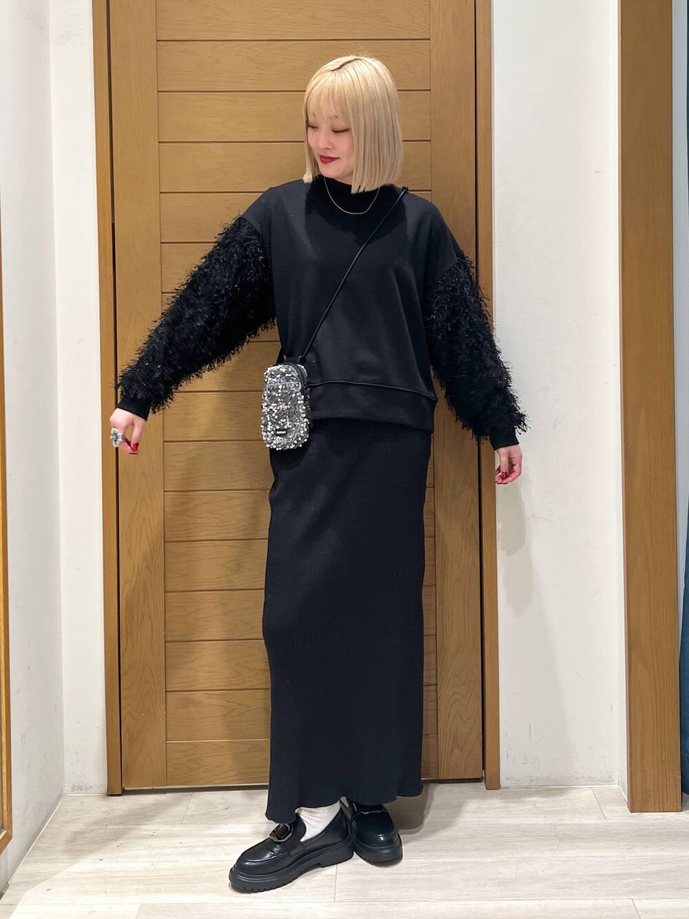 グレー系のショルダーバッグ、その他のローファー、ブラック系のスカートを着用したレディースの冬コーディネートの2枚目の写真