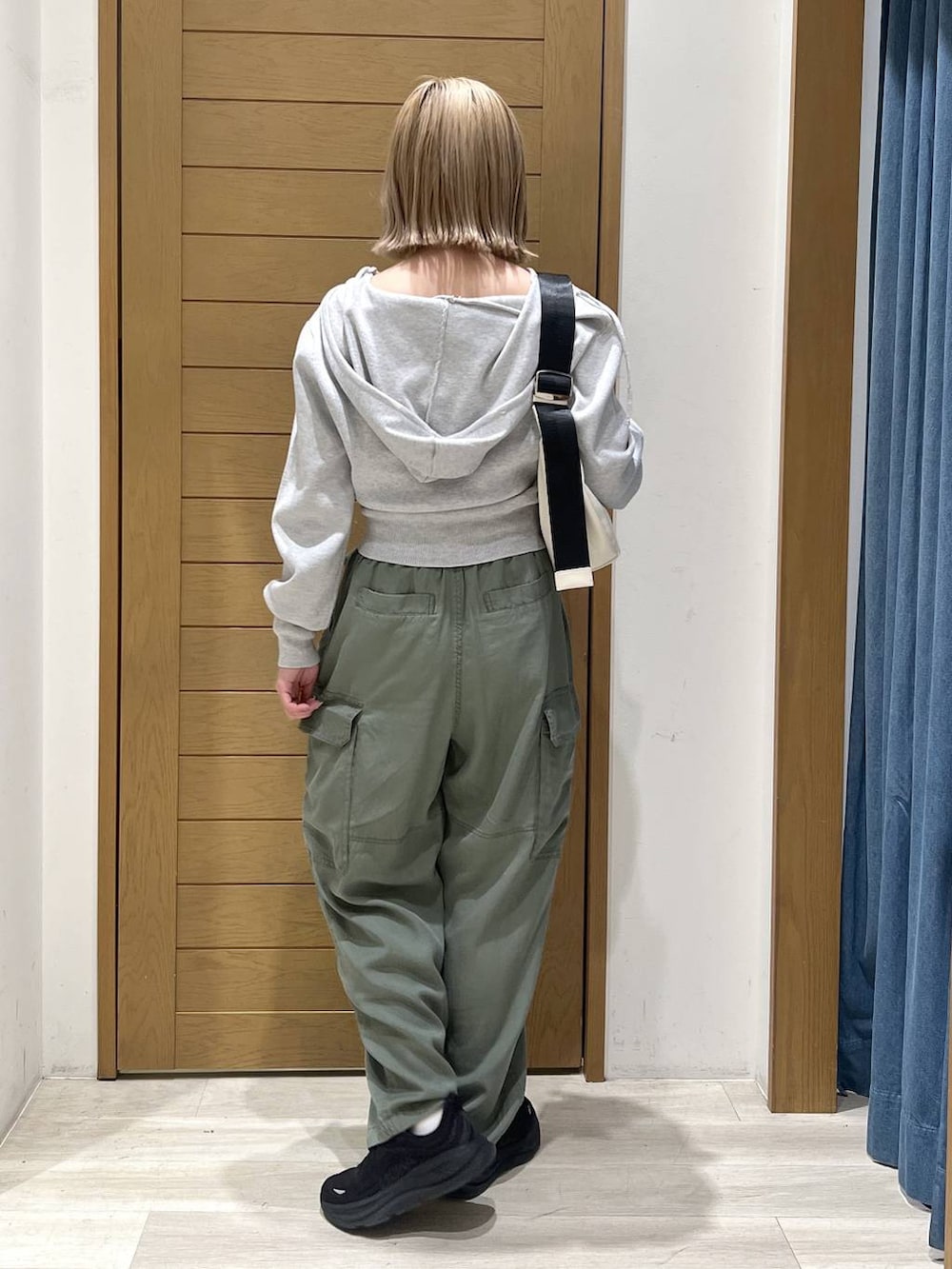 グリーン系のカーゴパンツ、ホワイト系のショルダーバッグ、グレー系のパーカーを着用したレディースの春コーディネートの5枚目の写真