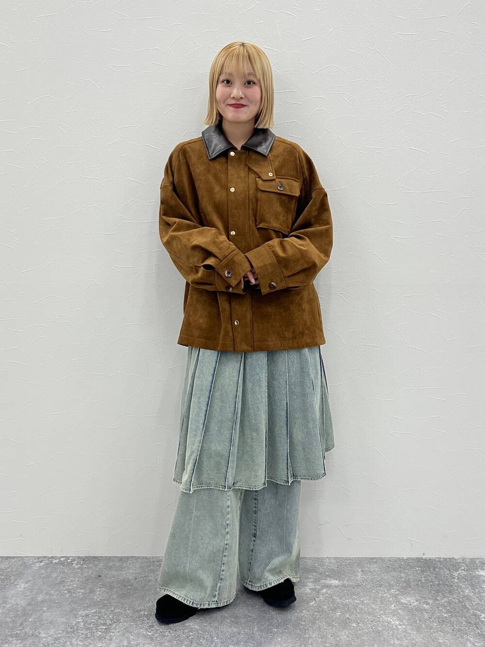 ブルー系のデニムパンツ、ブラウン系のブルゾンを着用したレディースの秋コーディネートの3枚目の写真