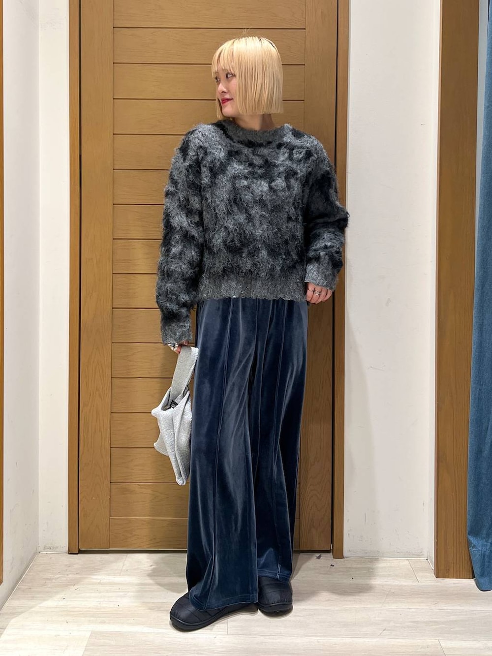 ブルー系のその他パンツ、グレー系のハンドバッグ、グレー系のニット/セーターを着用したレディースの冬コーディネートの2枚目の写真