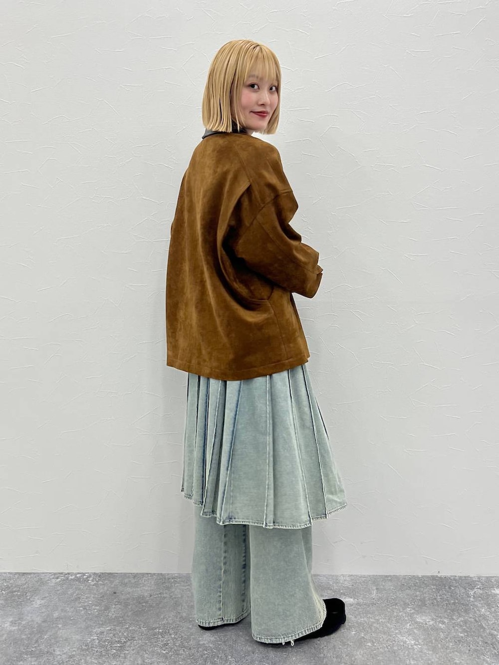 ブルー系のデニムパンツ、ブラウン系のブルゾンを着用したレディースの秋コーディネートの2枚目の写真