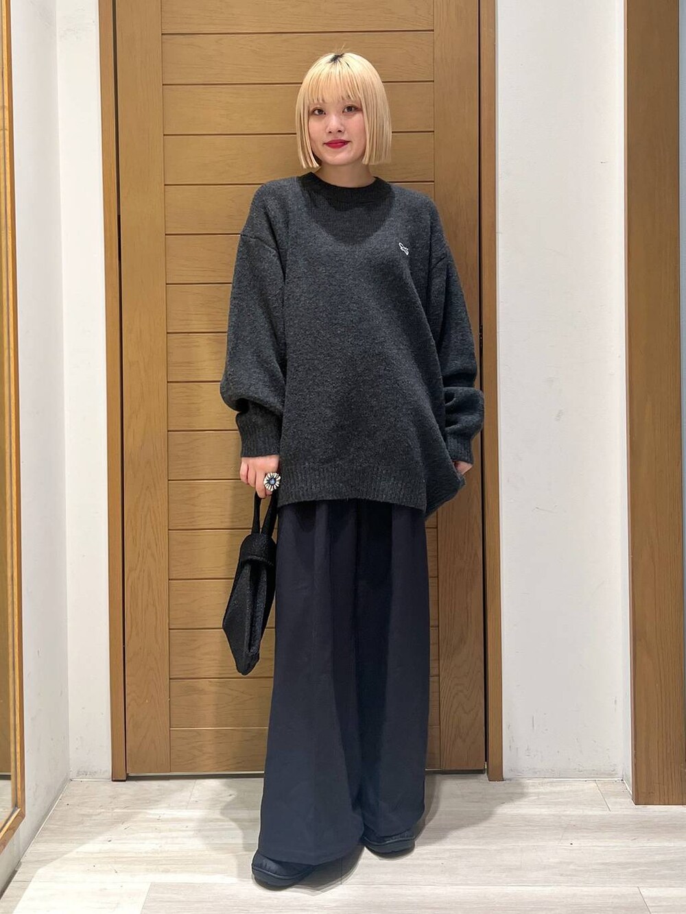 ブラック系のその他パンツ、グレー系のニット/セーター、ブラック系のハンドバッグを着用したレディースの冬コーディネートの5枚目の写真