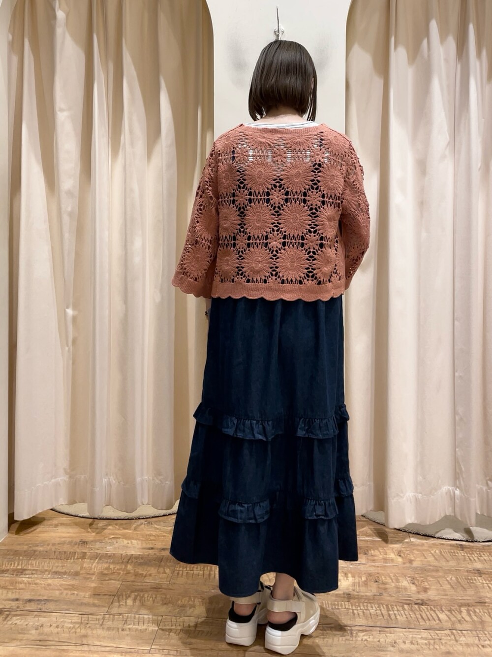 オレンジ系のカーディガン/ボレロ、ブルー系のワンピース、ホワイト系のタンクトップを着用したレディースの春コーディネートの2枚目の写真