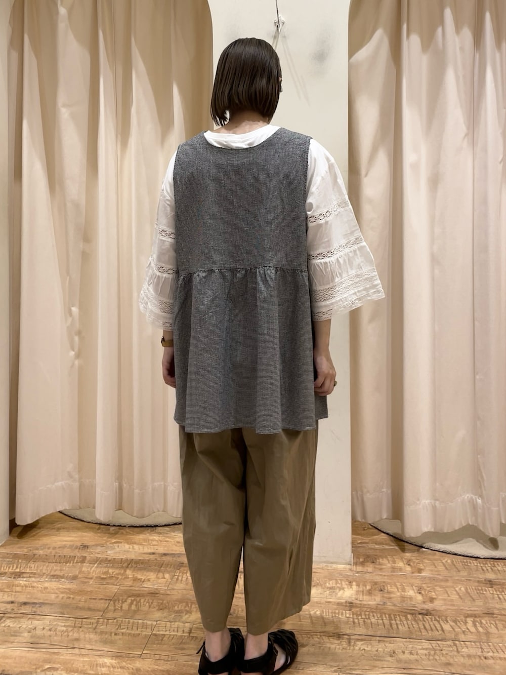 グレー系のベスト、ホワイト系のTシャツ/カットソー、ベージュ系のその他パンツを着用したレディースの春コーディネートの3枚目の写真