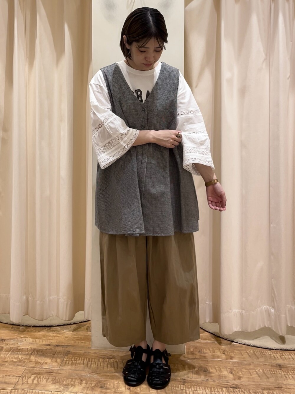 グレー系のベスト、ホワイト系のTシャツ/カットソー、ベージュ系のその他パンツを着用したレディースの春コーディネートの2枚目の写真