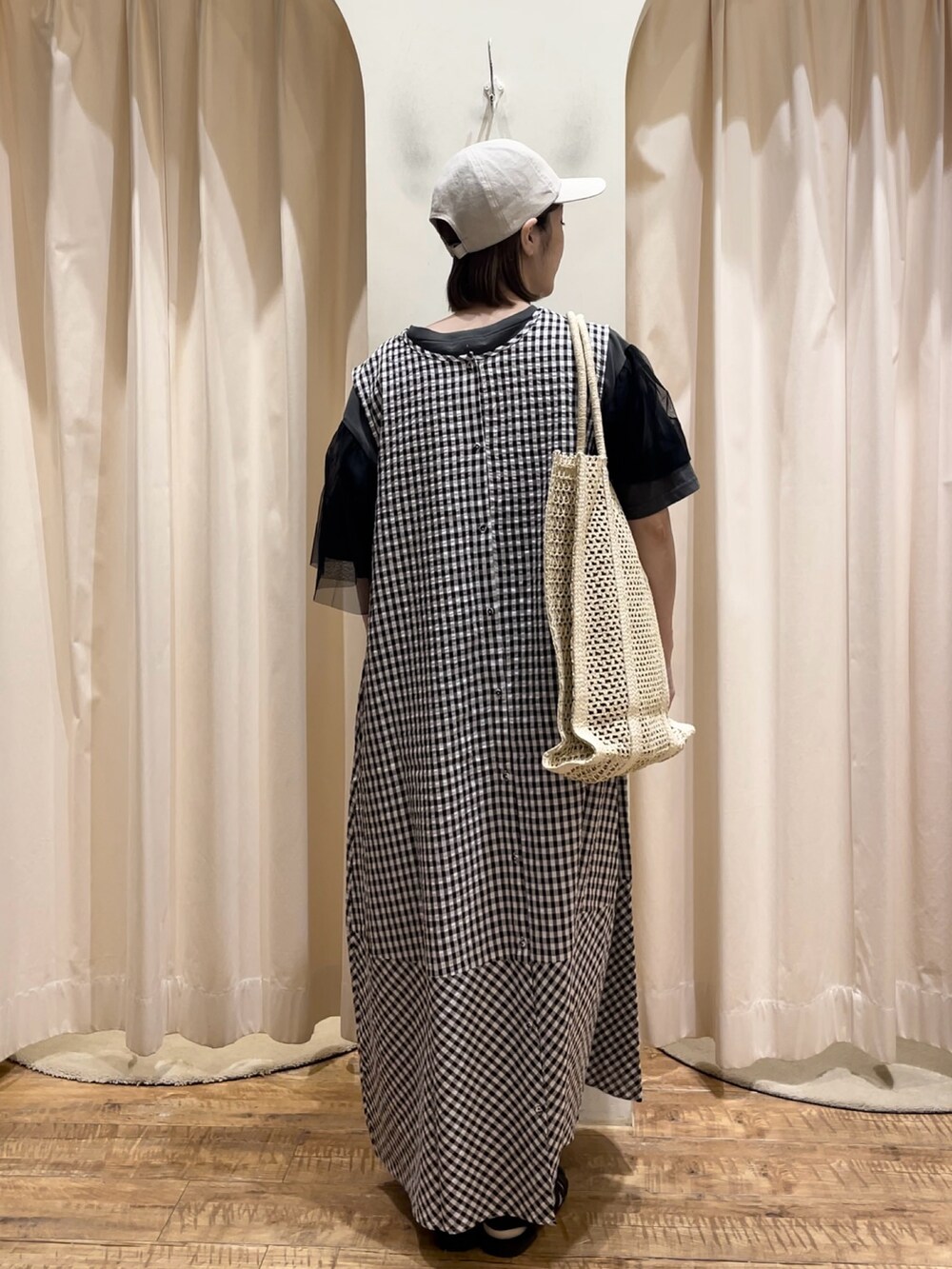 ブラウン系のワンピース、グレー系のTシャツ/カットソー、ホワイト系のハンドバッグを着用したレディースの春コーディネートの2枚目の写真