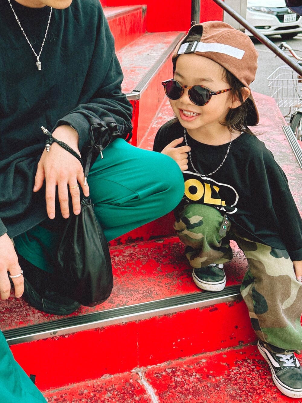 ブラック系のTシャツ/カットソー、グリーン系のカーゴパンツ、ブラック系のスニーカーを着用したキッズの春コーディネートの3枚目の写真