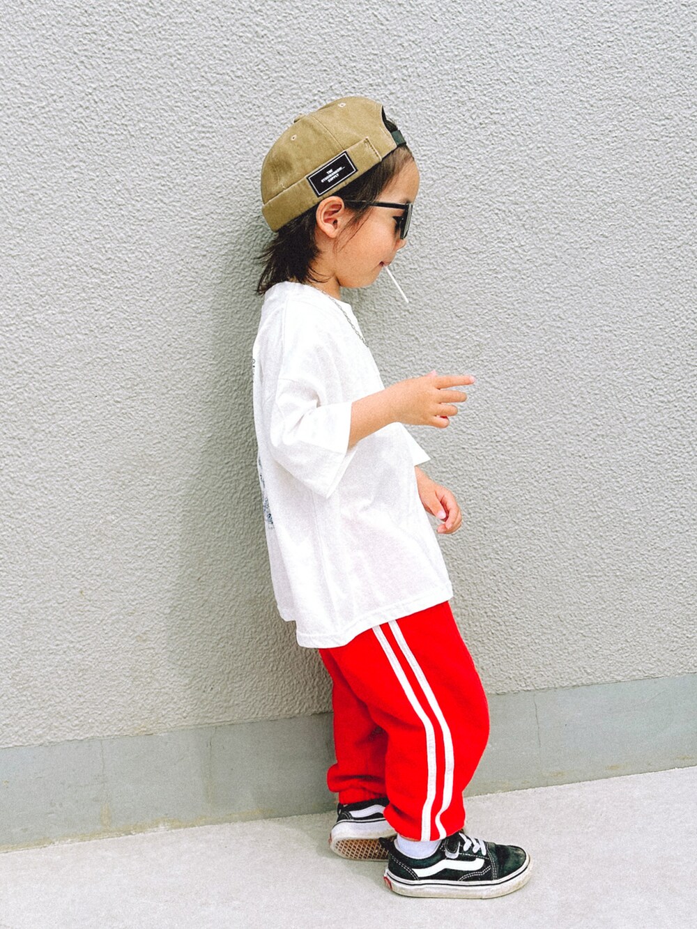 ホワイト系のTシャツ/カットソー、レッド系のスウェットパンツ、ブラック系のスニーカーを着用したキッズの春コーディネートの2枚目の写真