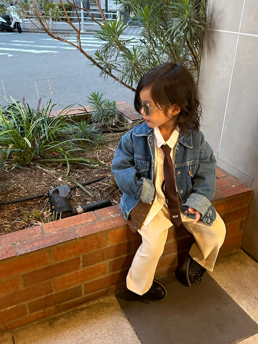 ブラウン系のネクタイ、ブルー系のデニムジャケット、ホワイト系のシャツ/ブラウスを着用したキッズの秋コーディネートの2枚目の写真