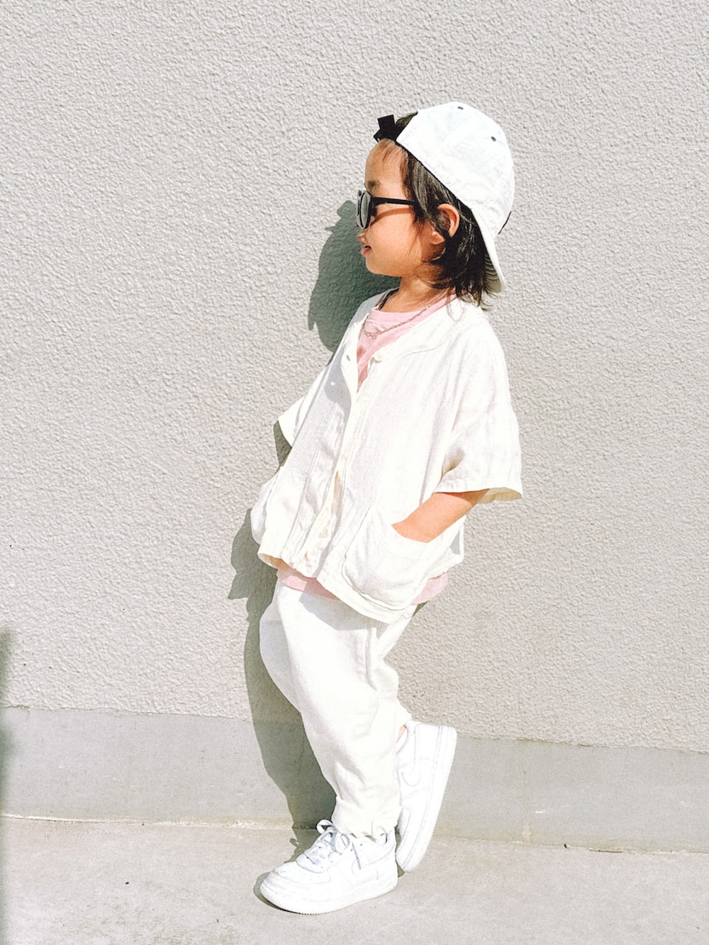 ホワイト系のデニムパンツ、ホワイト系のスニーカー、ホワイト系のシャツ/ブラウスを着用したキッズの春コーディネートの2枚目の写真