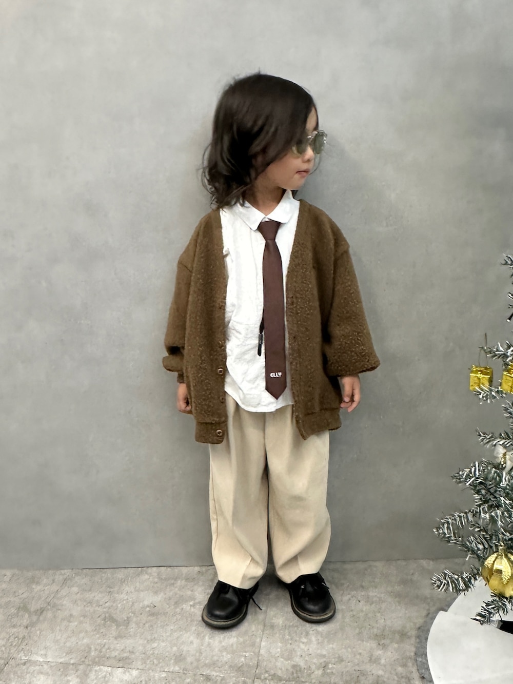 ブラウン系のネクタイ、ブルー系のデニムジャケット、ホワイト系のシャツ/ブラウスを着用したキッズの秋コーディネートの3枚目の写真