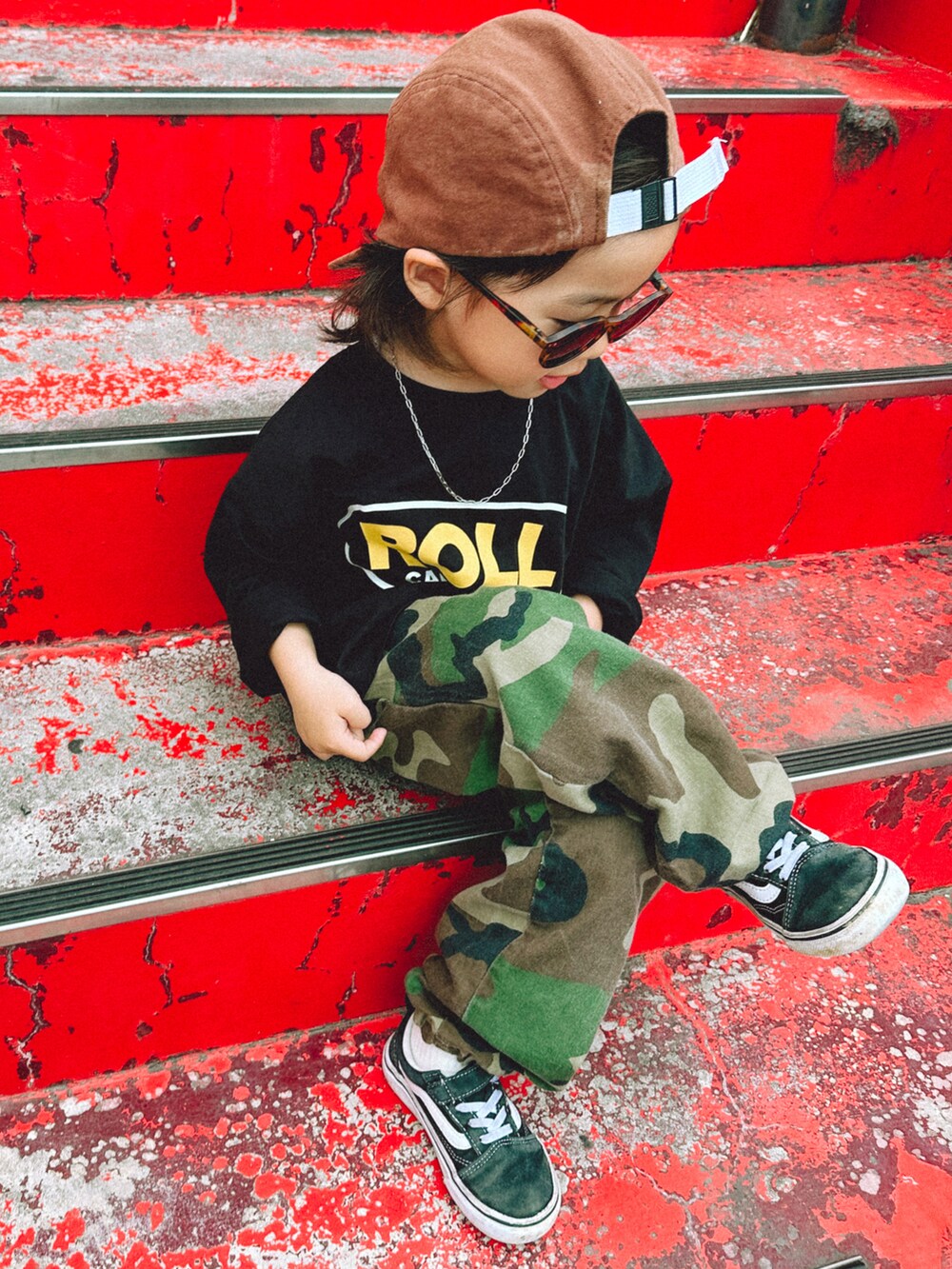 ブラック系のTシャツ/カットソー、グリーン系のカーゴパンツ、ブラック系のスニーカーを着用したキッズの春コーディネートの2枚目の写真