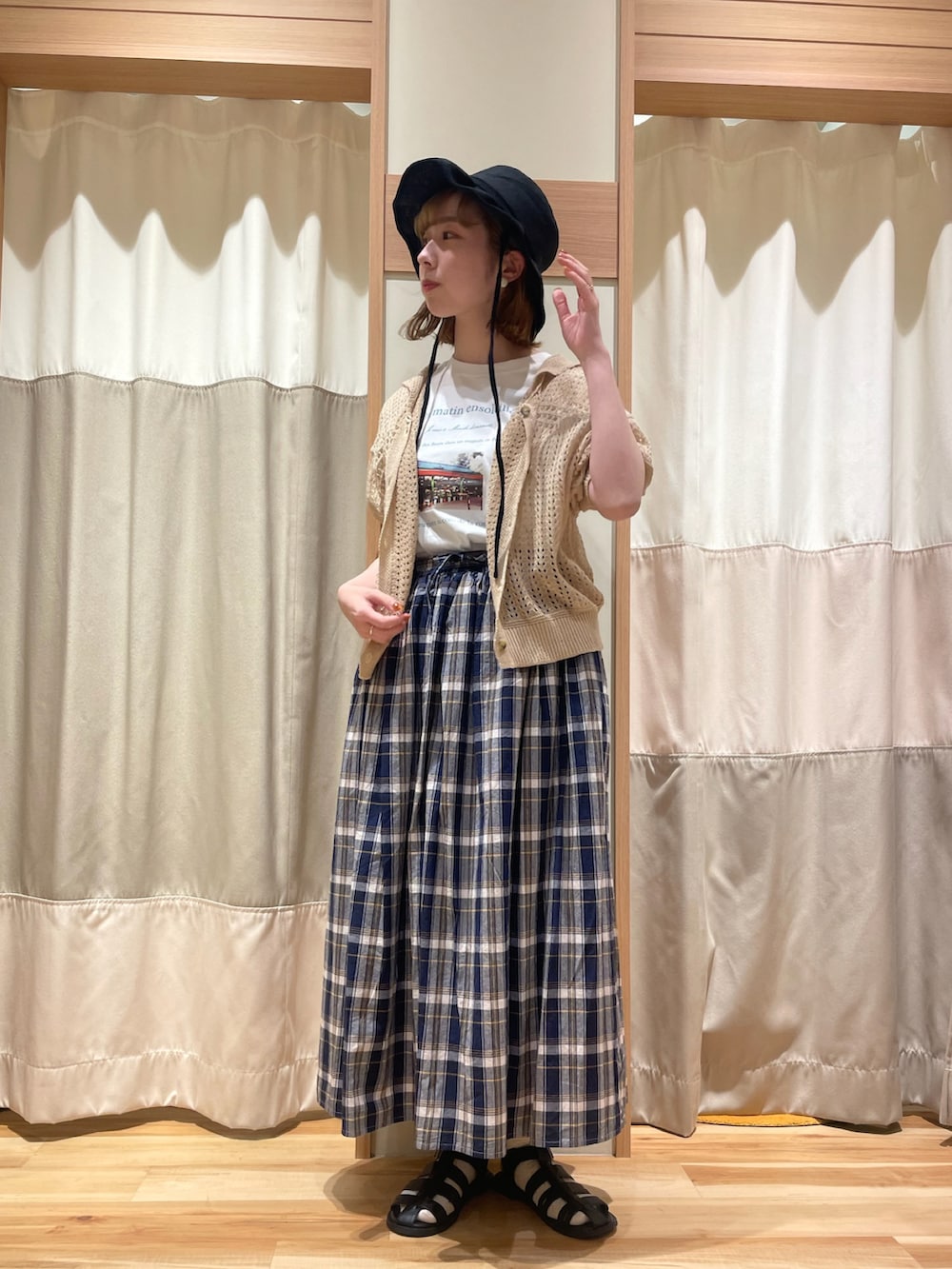 ホワイト系のTシャツ/カットソー、ベージュ系のカーディガン/ボレロ、ブルー系のスカートを着用したレディースの春コーディネートの2枚目の写真