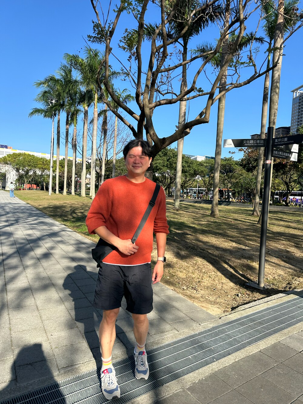 ベージュ系のスニーカー、ブラック系のカーゴパンツ、オレンジ系のTシャツ/カットソーを着用したメンズの冬コーディネートの2枚目の写真