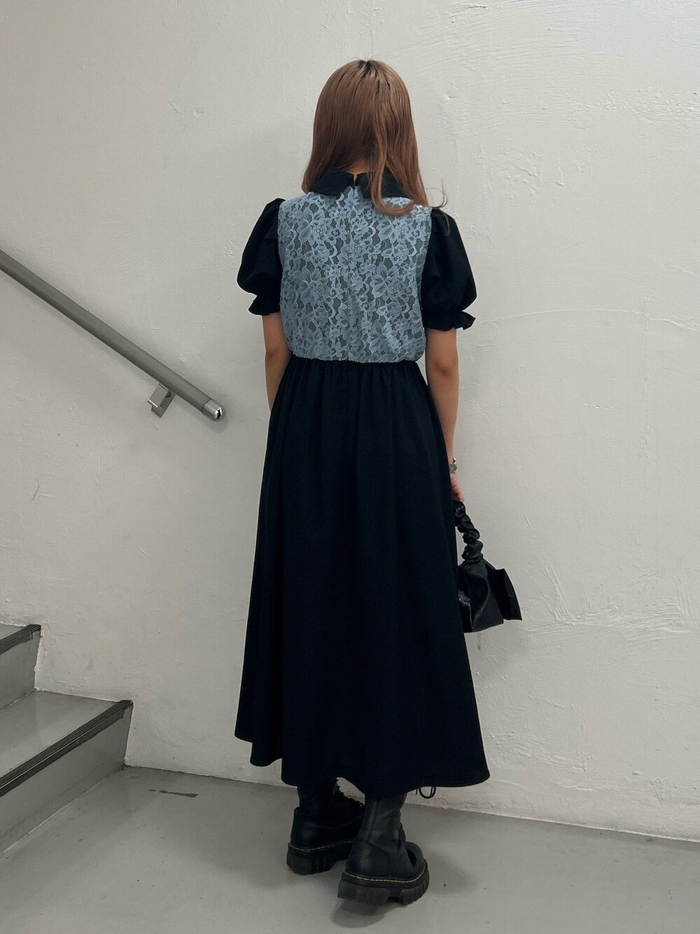 ブラック系のワンピース、ブラック系のハンドバッグ、シルバー系のブレスレットを着用したレディースの春コーディネートの3枚目の写真