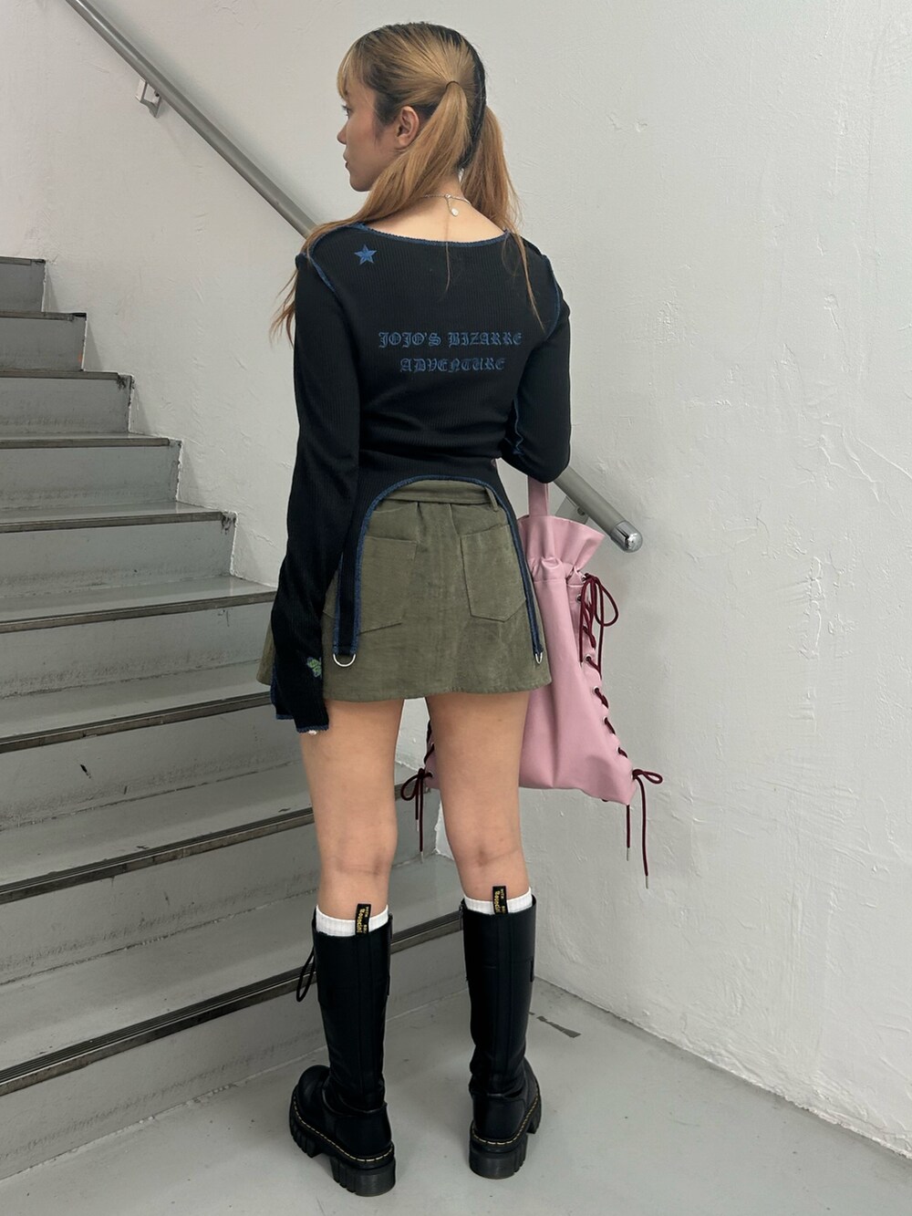 ブラック系のTシャツ/カットソー、グリーン系のスカート、ピンク系のトートバッグを着用したレディースの秋コーディネートの3枚目の写真