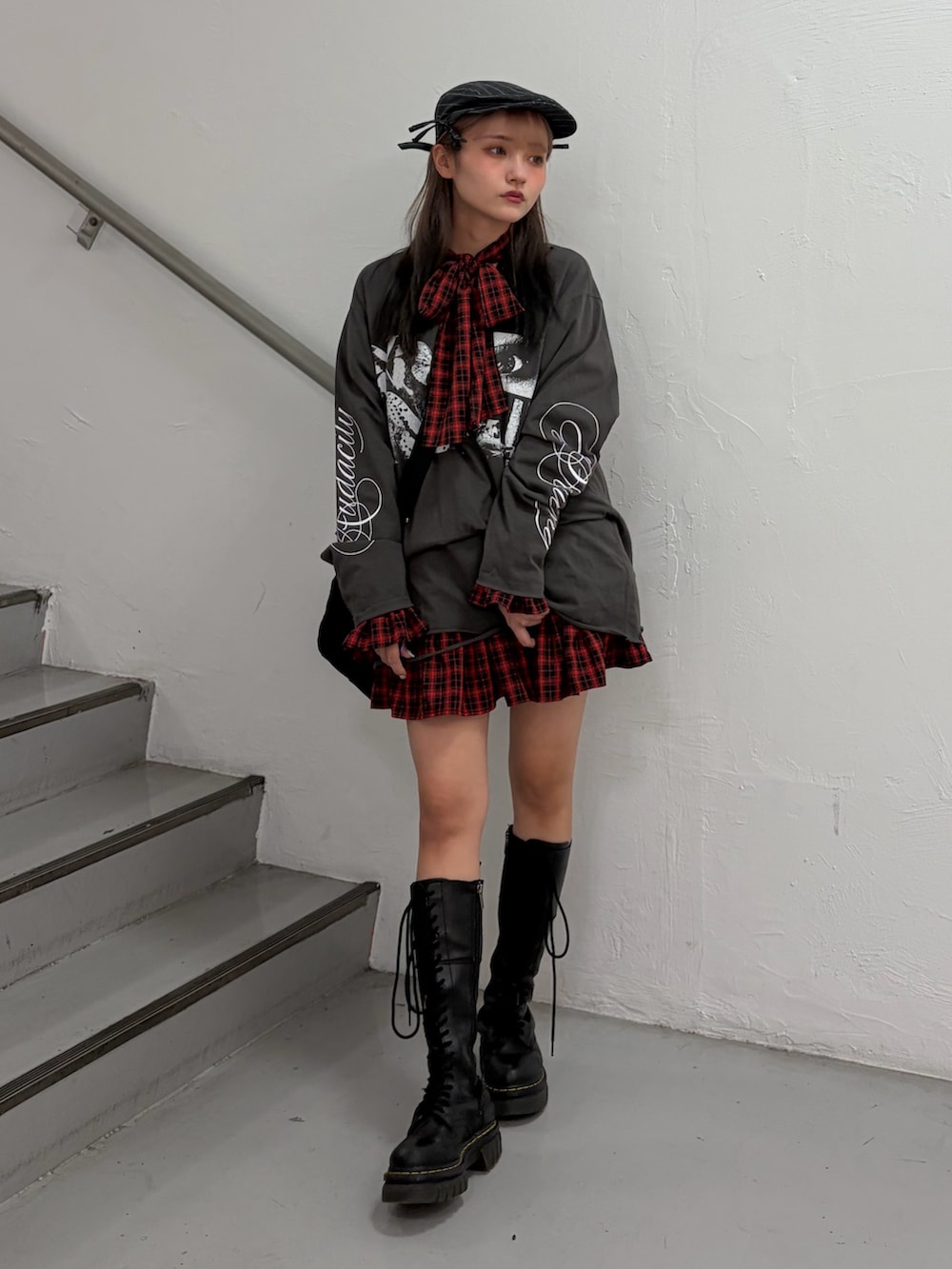 ブラック系のTシャツ/カットソー、レッド系のワンピース、ブラック系のボストンバッグを着用したレディースの冬コーディネートの4枚目の写真