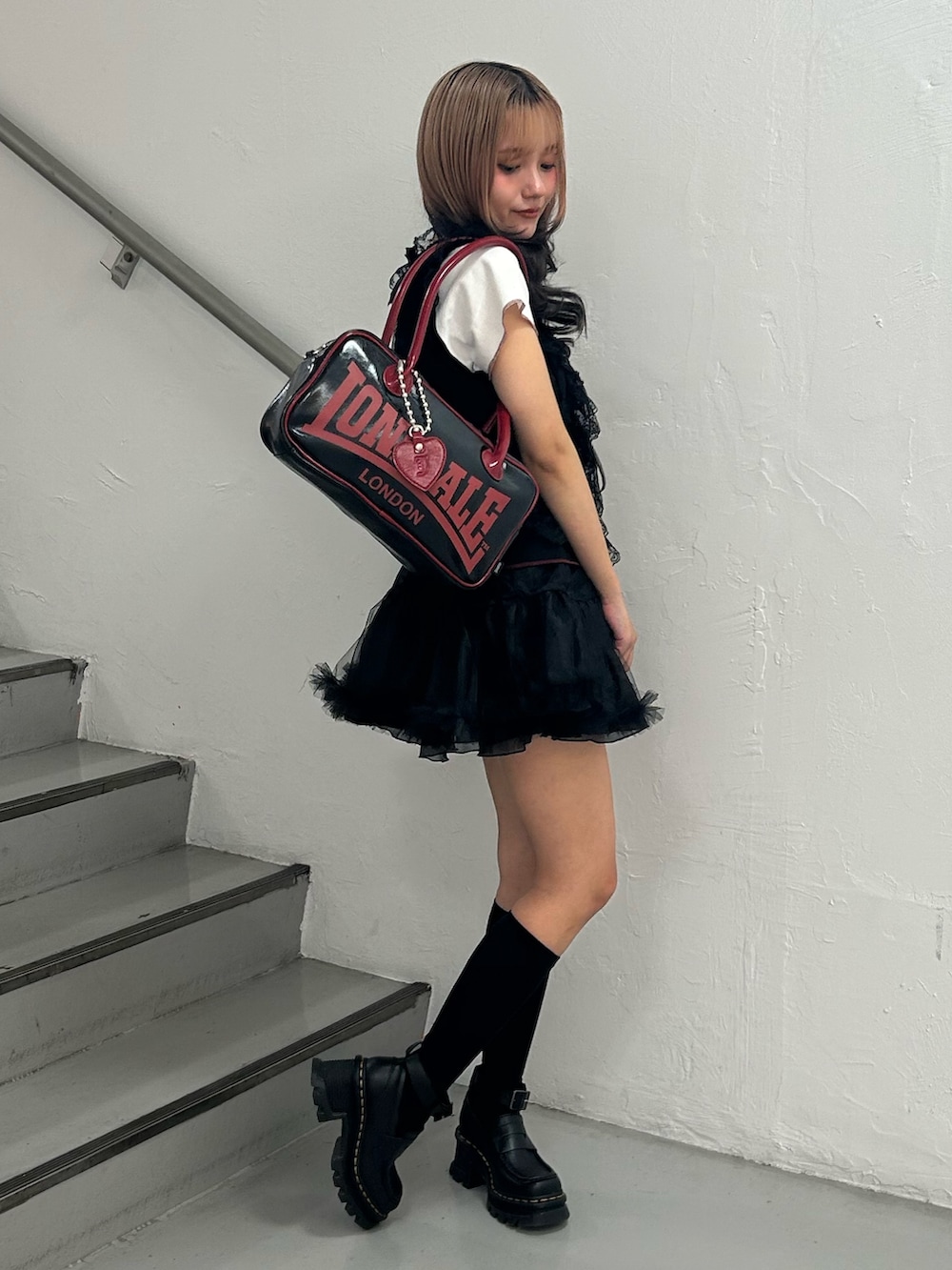 ブラック系のTシャツ/カットソー、ブラック系のスカート、ブラック系のボストンバッグを着用したレディースの夏コーディネートの2枚目の写真