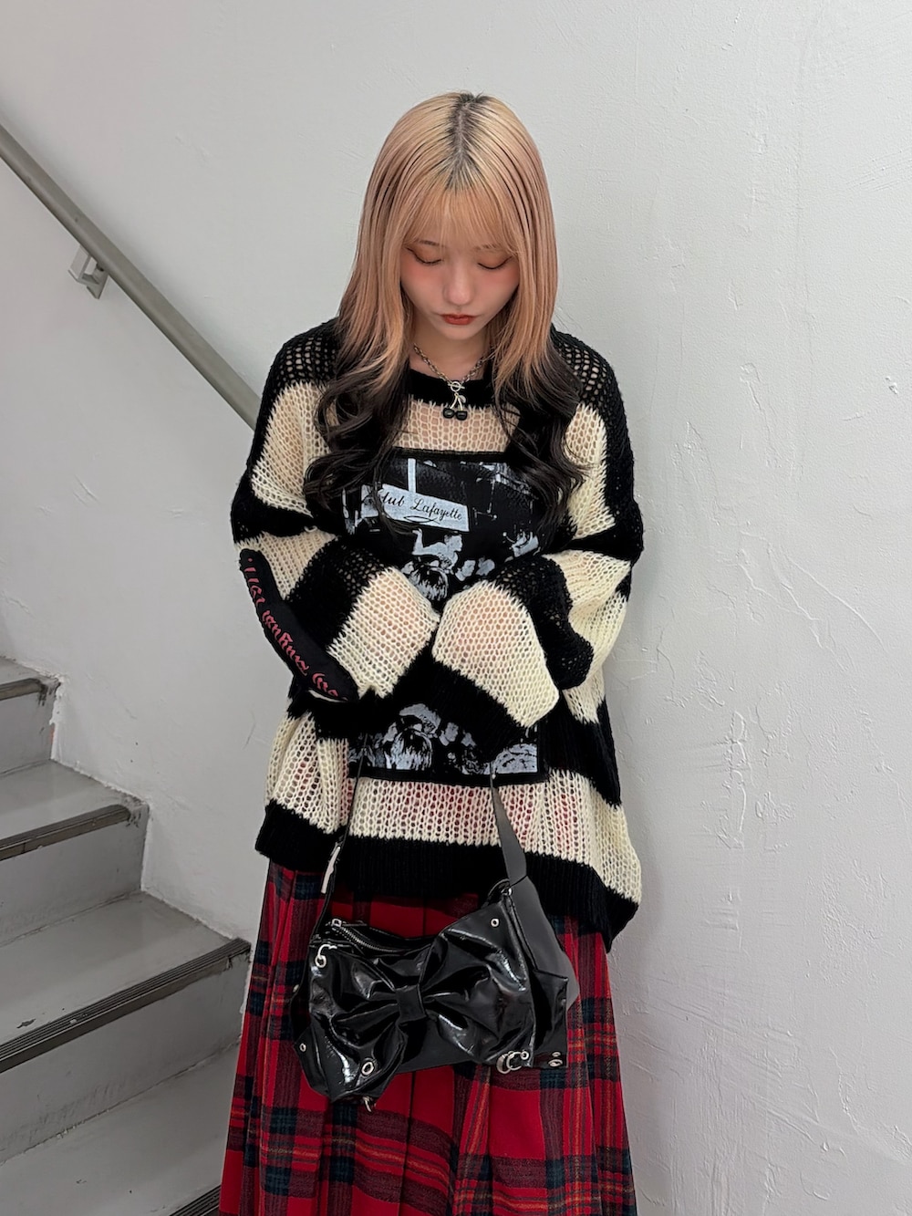 その他のニット/セーター、レッド系のスカート、ブラック系のショルダーバッグを着用したレディースの秋コーディネートの4枚目の写真