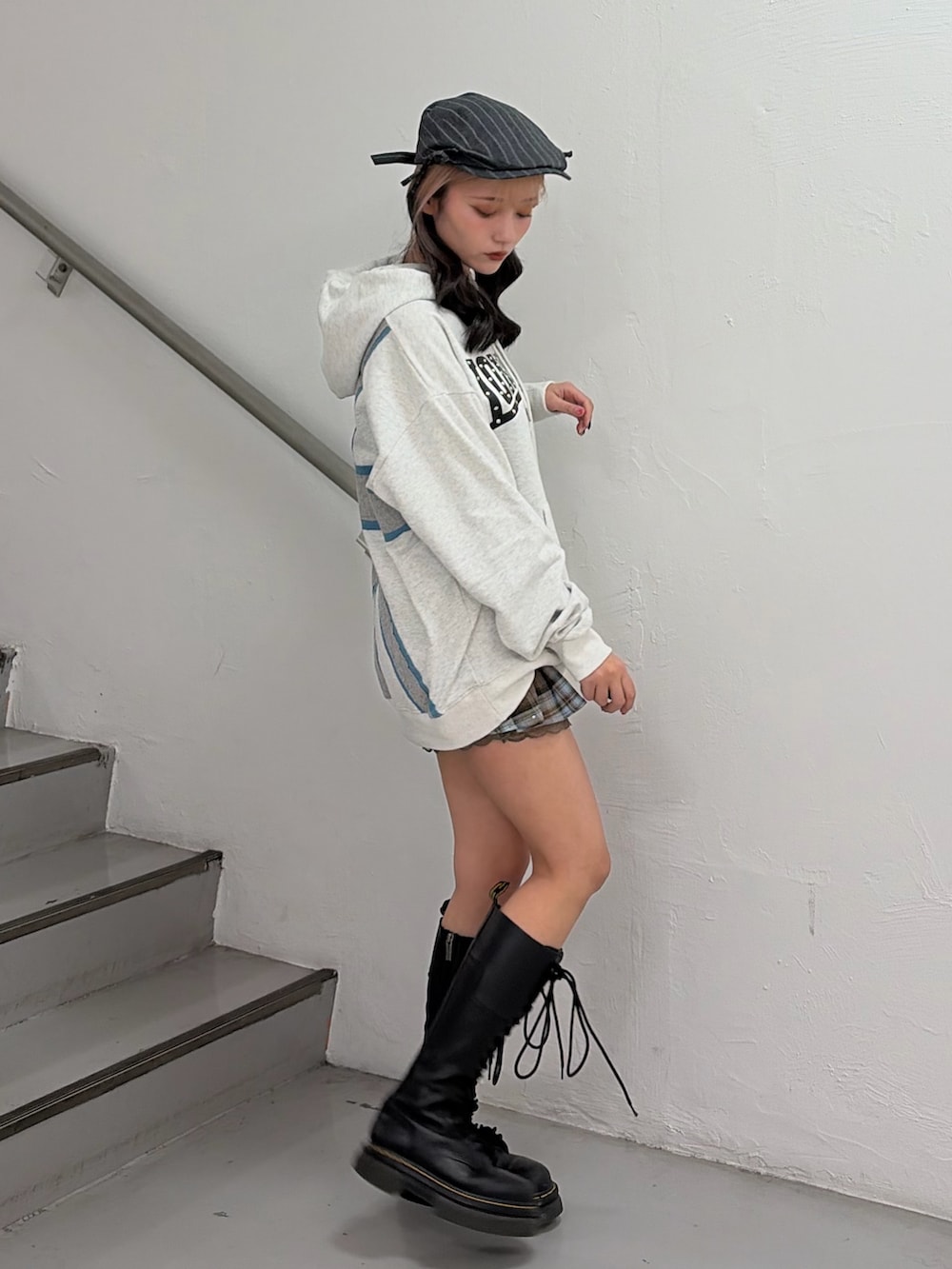 ホワイト系のパーカー、ブラウン系のスカートを着用したレディースの冬コーディネートの2枚目の写真