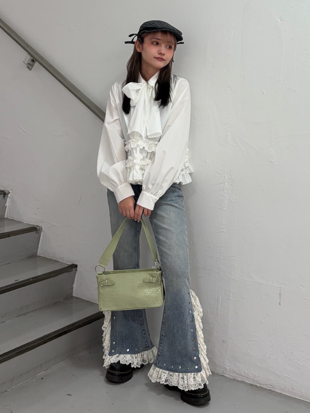 ホワイト系のシャツ/ブラウス、ブルー系のデニムパンツ、グリーン系のハンドバッグを着用したレディースの冬コーディネートの2枚目の写真